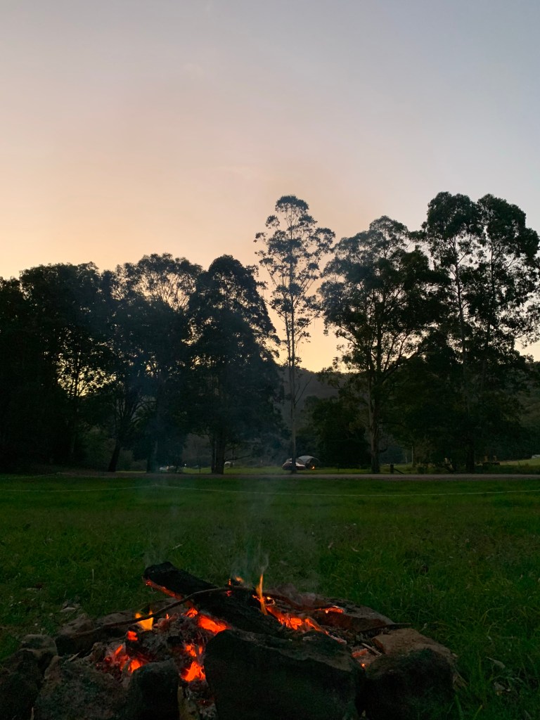 Warming up at the campfire  watching the sunset
